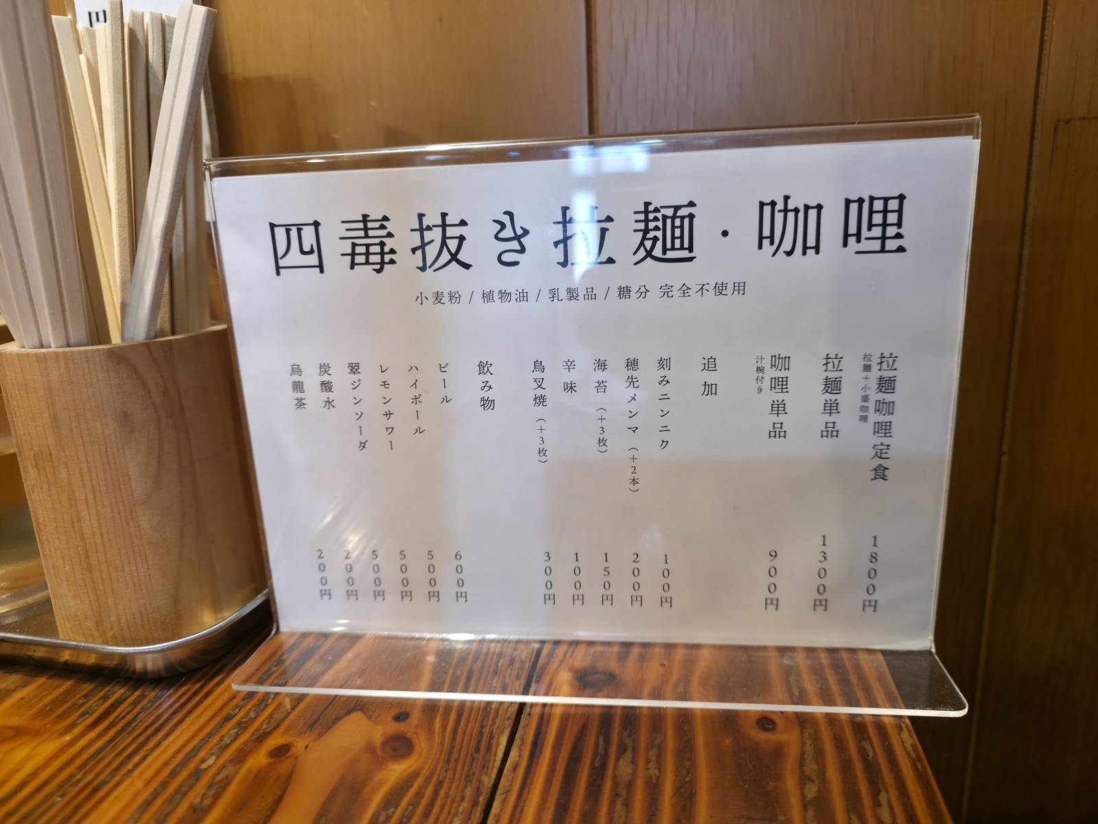 店内のメニュー。四毒抜き拉麺・咖喱、追加トッピング、ドリンク